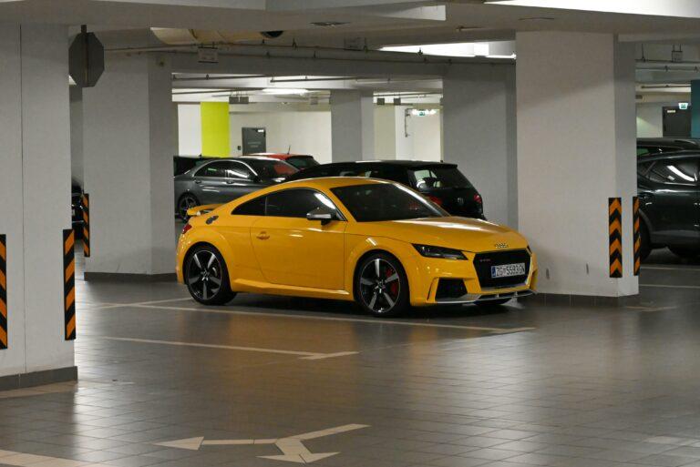 Stellplatzmarkierungen und ein gelbes Auto in einem Parkhaus