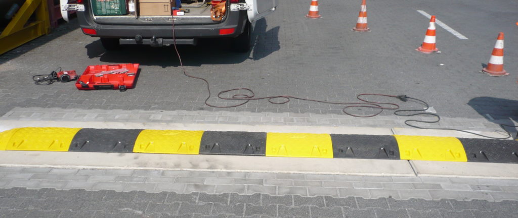 gelb-schwarze Streifen auf der Straße und gelbe Verkehrhütchen