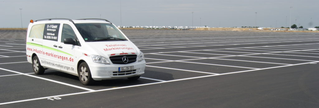 ein weißer Lieferwagen, der auf einem Parkplatz geparkt ist