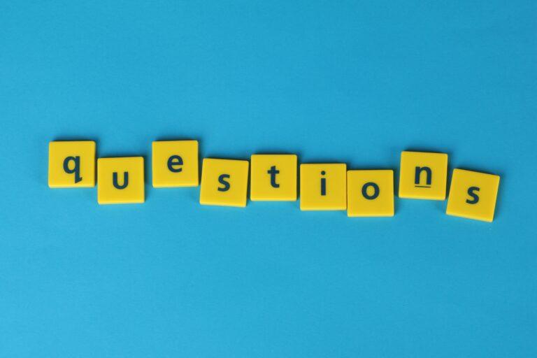 FAQ als Bild dargestellt auf blauem Hintergrund mit gelben PLättchen auf denen das Wort question steht